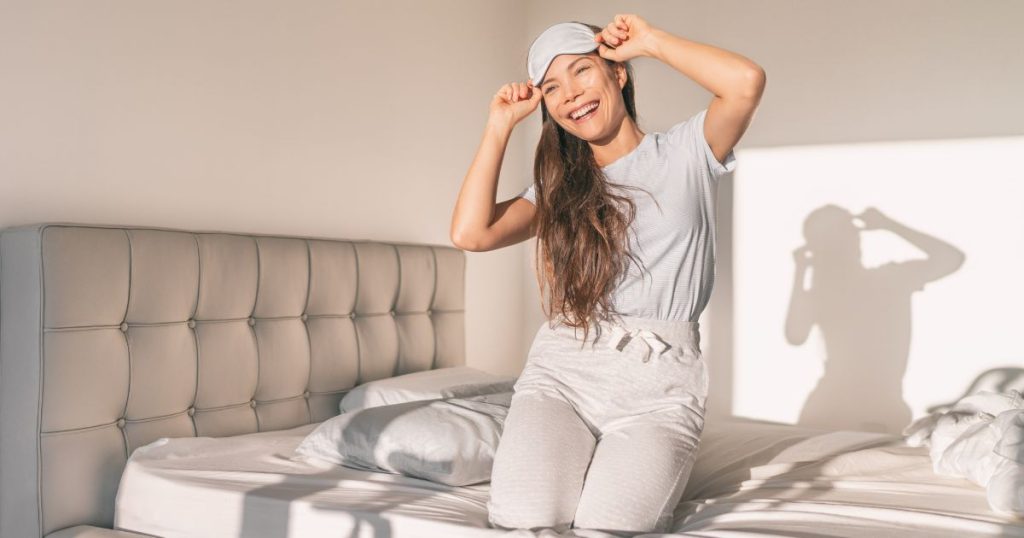 Woman smiling as she removes her sleep mask