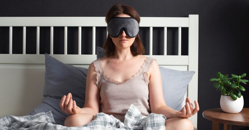 Woman meditating before bed to try sleep better